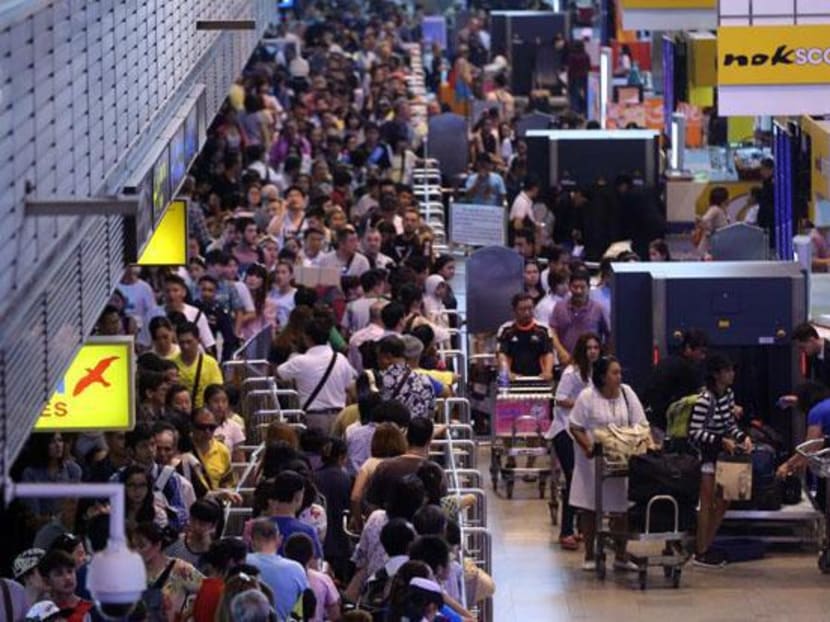 Passengers pack the terminal of Don Mueang airport on Monday, July 20, waiting to pass through x-ray screening for all luggage. Photo: Bangkok Post