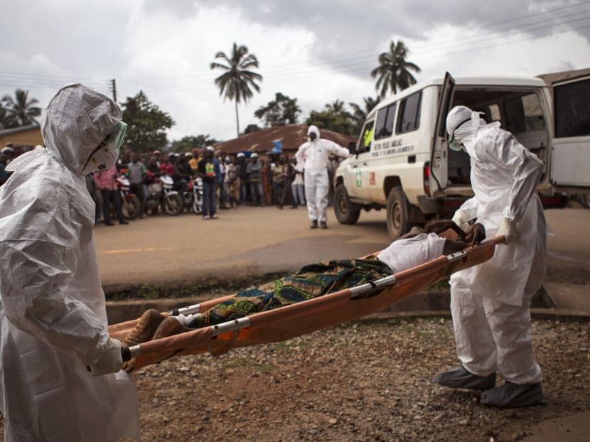 In this Wednesday, Sept. 24, 2014 file photo, healthcare workers load a man suspected of suffering from the Ebola virus onto an ambulance in Kenema, Sierra Leone. Photo: AP