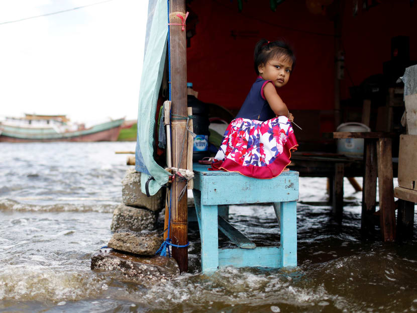 A girl sits on a bench at Kali Adem port, which is impacted by high tides due to the rising sea level and land subsidence, north of Jakarta, Indonesia on Nov 20, 2020.