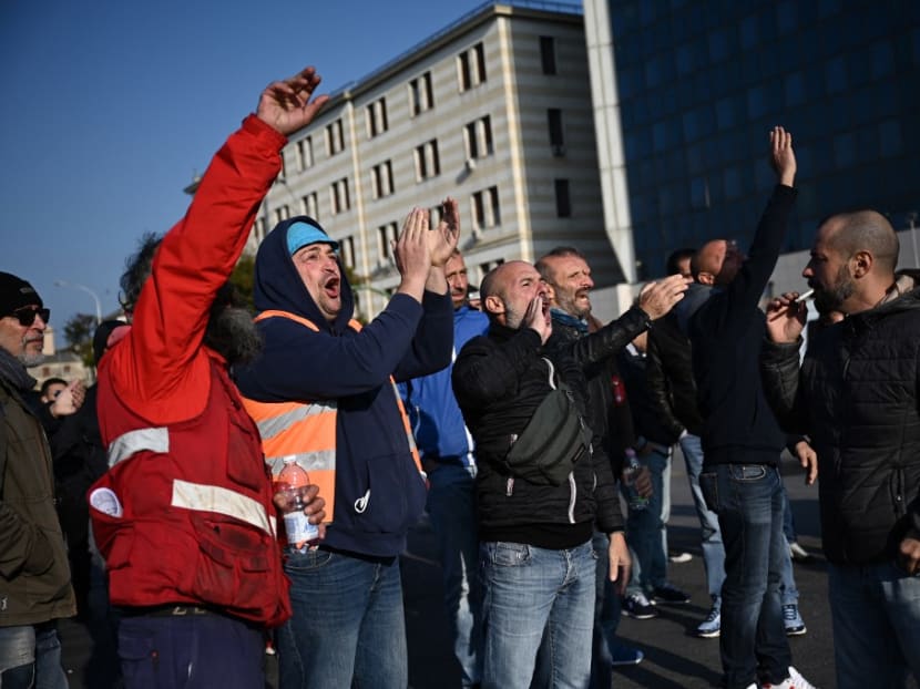 Workers react as they block port operations at the Etiopia gate (Varco Etiopia) in the port of Genoa, Liguria, on October 15, 2021 as new coronavirus restrictions for workers come into effect.