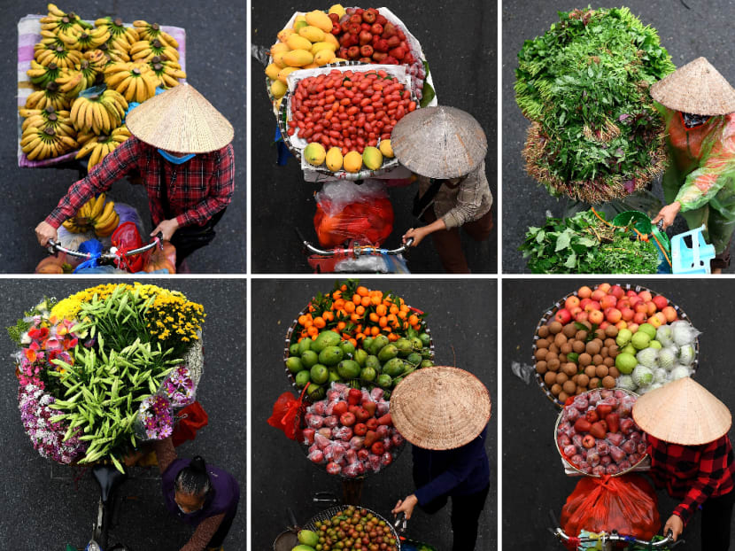 Vendors carry various goods for sale on their bicycles in Hanoi on March 18, 2021.
