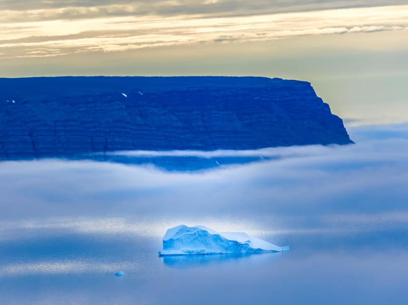 Icebergs seen through the fog float in the Baffin Bay near Pituffik, Greenland on July 20, 2022.