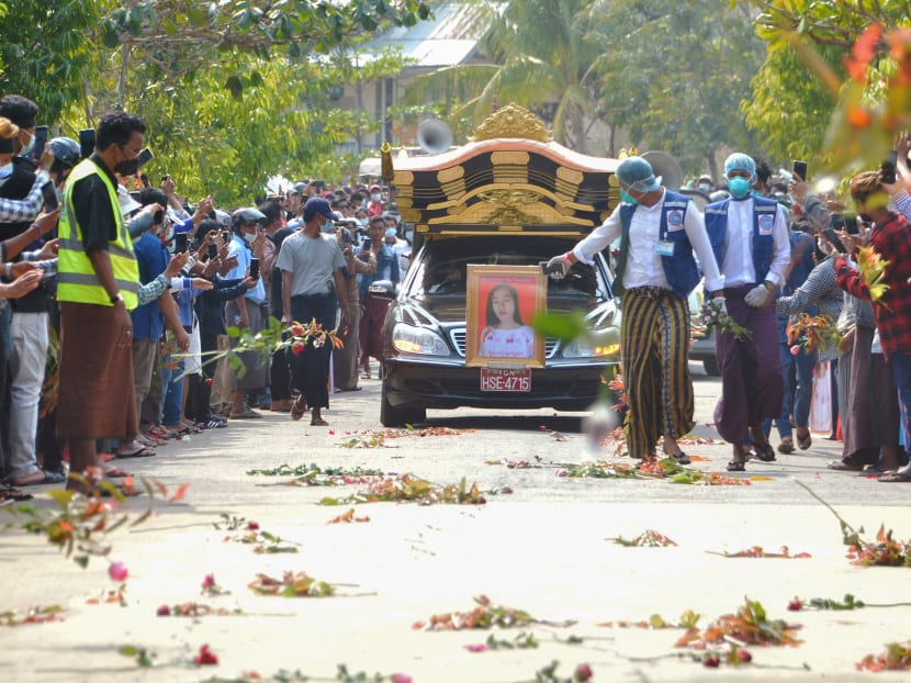 People line the street throw flowers on the road as the car carrying the body of protester Mya Thwate Thwate Khaing passes during her funeral service, after she died following being shot during a rally against the military coup, in Naypyidaw on Feb 21, 2021.