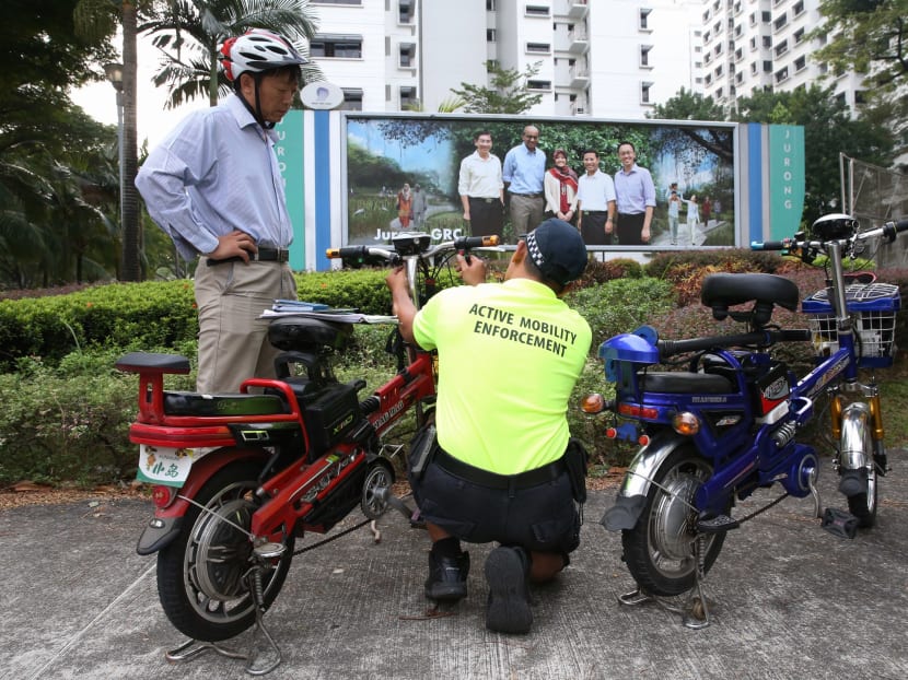 An LTA Active Mobility Enforcement Officer checking a power-assisted bicycle for illegal modifications at Yung Sheng Road. Photo: Koh Mui Fong
