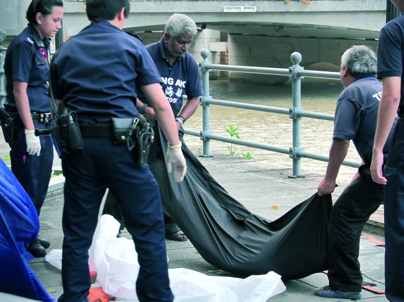 Police retrieving a body from the Singapore River outside the Riverside at Boat Quay yesterday. Photo: DORALYNN TAN