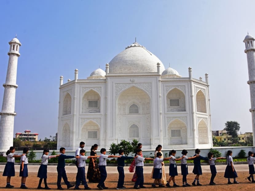 In this photograph taken on Nov 25, 2021, school children walk past a replica of the Taj Mahal during their visit at Burhanpur in India's Madhya Pradesh state.