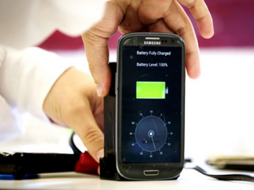 A lab worker disconnects from a charger a mobile phone, displaying a timer indicating that the battery was fully charged under 30 seconds, at the headquarters of StoreDot in Tel Aviv October 23, 2014. The Israeli company says it has developed technology that can charge a mobile phone in a few seconds and an electric car in minutes, advances that could transform two of the world's most dynamic consumer industries. Picture taken October 23, 2014. REUTERS/Finbarr O'Reilly (ISRAEL - Tags: BUSINESS SCIENCE TECHNOLOGY TRANSPORT TELECOMS)