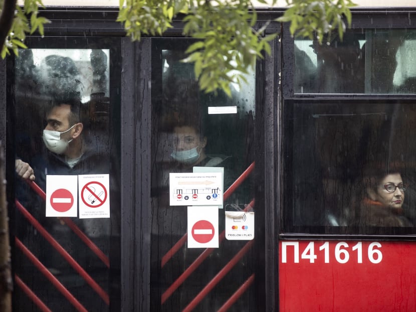 People wearing protective face masks ride a bus in Belgrade on Oct 11, 2021.