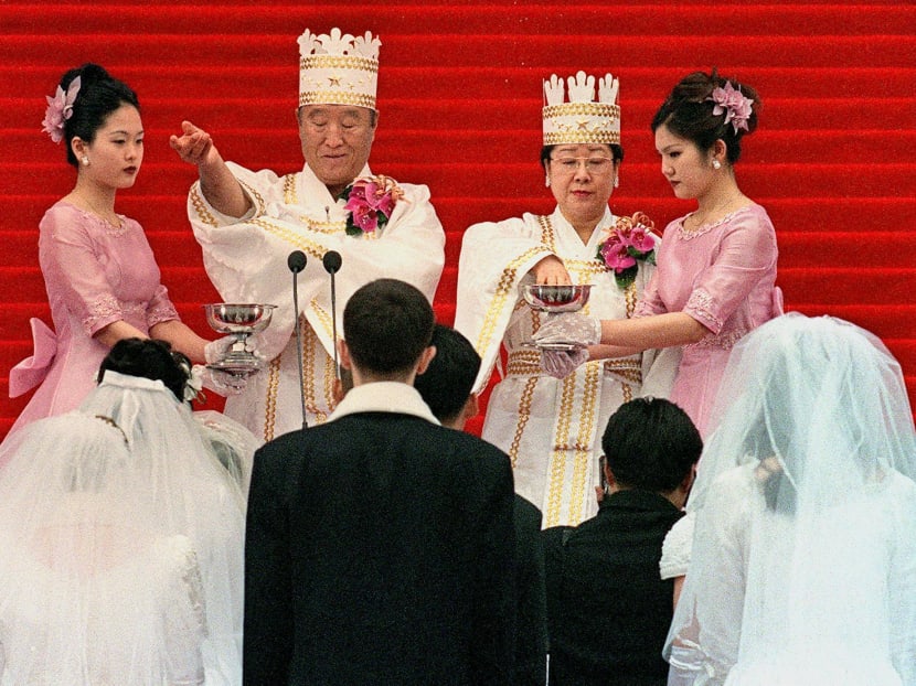 Sun Myung Moon (second to the left), founder of the Unification Church, and his wife (second to the right) bless the brides and the grooms in a mass wedding ceremony at Chamsil Olympic Stadium in Seoul Feb 13 2000. The Unification Church, also known as Moonie, was among the cults that exists in South Korea. Photo: AFP