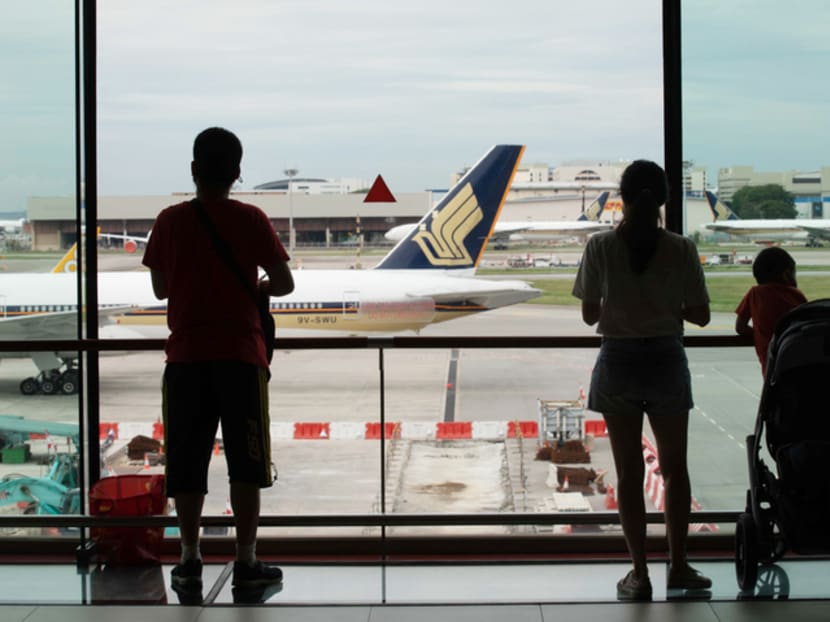 People looking at a Singapore Airlines plane at Changi Airport.