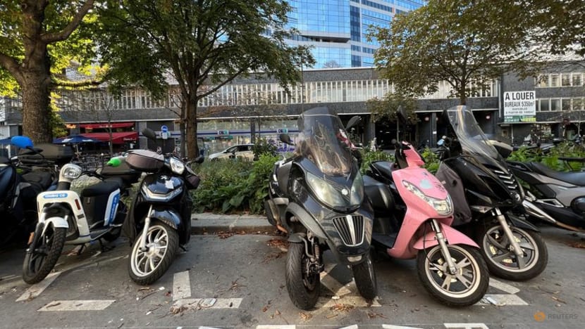 Resigned riders of gasoline-fuelled motorbikes pay for parking in Paris Resigned riders of gasoline-fuelled motorbikes pay for parking in Paris