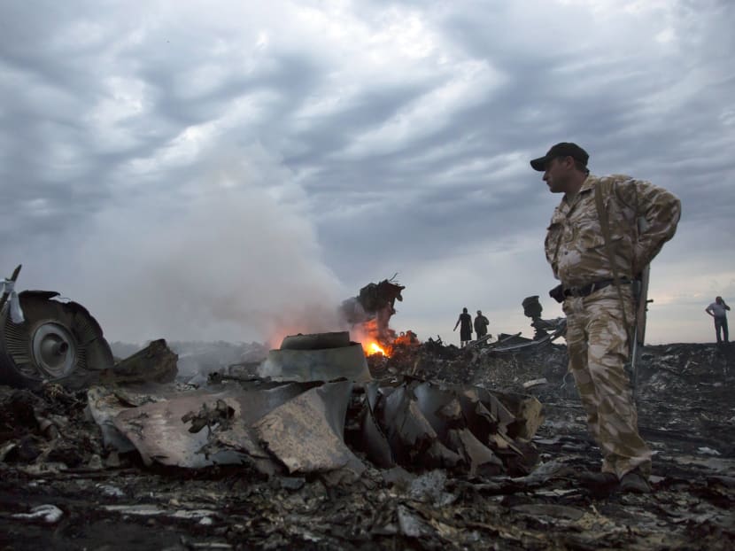 People walk amongst the debris, at the crash site of Malaysia Airlines MH17 near the village of Grabovo, Ukraine, Thursday, July 17, 2014.  Photo: AP