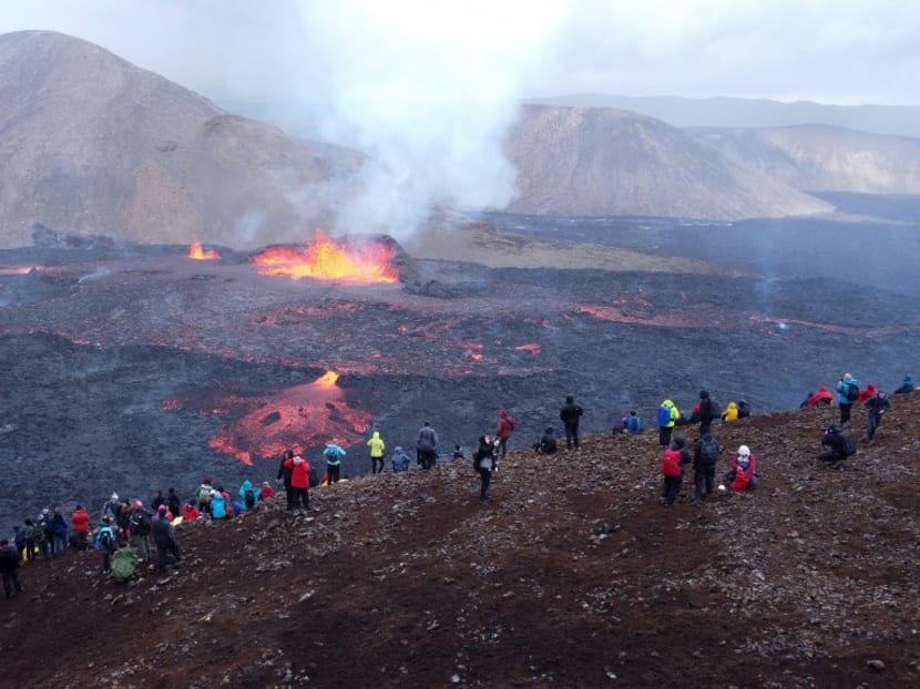 Onlookers and tourists watch as lava flows from the vulcano in Fagradalsfjall, Iceland, around 40 kilometres from the capital Reykjavik, on Aug 10, 2022, following an eruption that has been ongoing since Aug 3, 2022. Onlookers and tourists watch as lava flows from the vulcano in Fagradalsfjall, Iceland, around 40 kilometres from the capital Reykjavik, on Aug 10, 2022, following an eruption that has been ongoing since Aug 3, 2022.