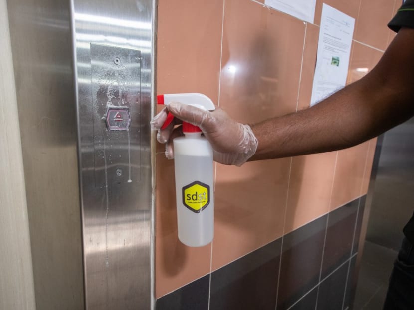 The disinfecting coating agent called "Sdst" being applied to lift buttons at public housing blocks.