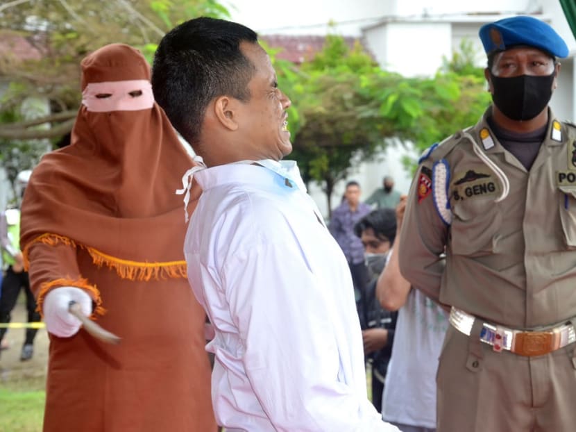 A man is publicly flogged by a member of the Sharia police after he was found guilty of raping a child, in Idi Rayeuk, East Aceh on Nov 26, 2020.