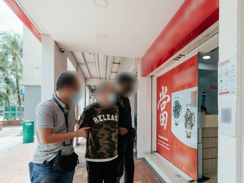 A robbery suspect being led to a pawnshop in Woodlands after his arrest. A robbery suspect being led to a pawnshop in Woodlands after his arrest.