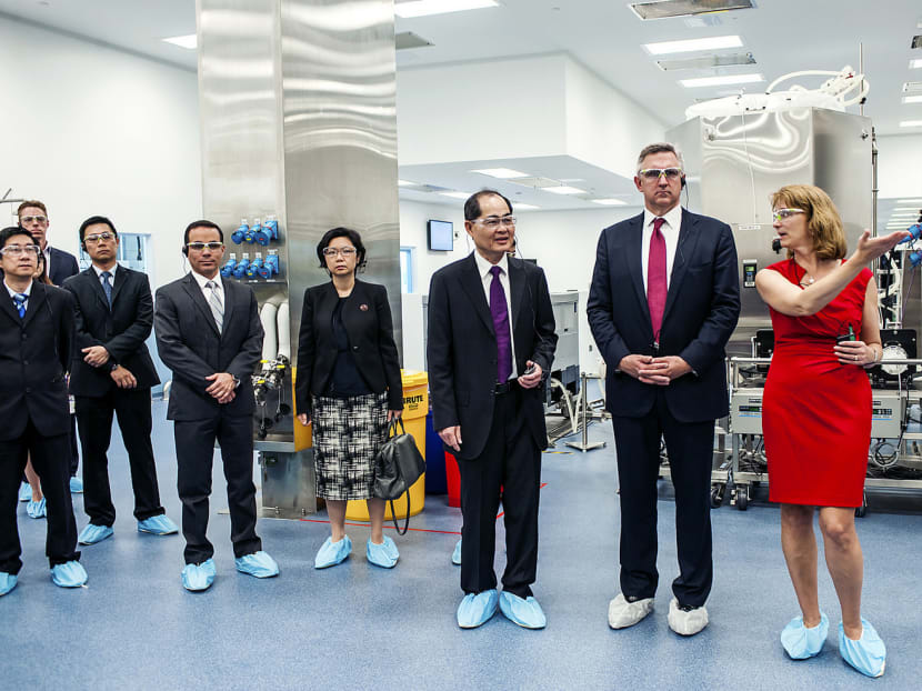 Amgen chief executive Robert Broadway (second from right) and Amgen’s Singapore head and vice-president for manufacturing Kimball Hall (right) leading guests, including Trade and Industry Minister Lim Hng Kiang (third from right), on a tour around the facility in Tuas. PHOTO: Amgen Singapore Manufacturing Pte Ltd