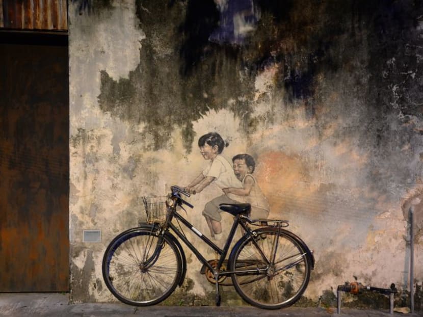 News report said the iconic Children on a Bicycle mural was splashed with dhal curry, spray painted yellow and stickers pasted all over the mural. Photo: Malay Mail Online