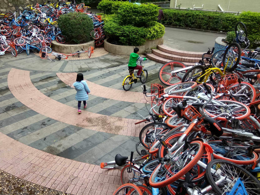 Scores of rented bicycles from bike-sharing firms are dumped near the entrance of Xiashan park in Shenzhen. Photo: AFP