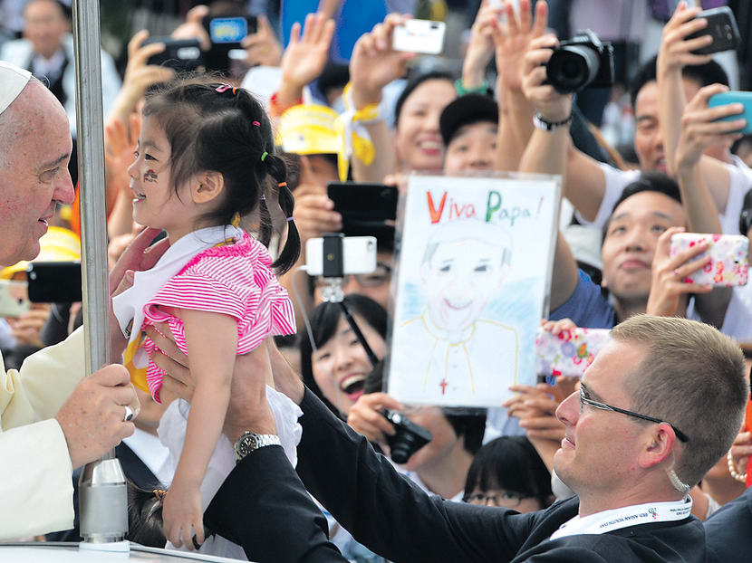 Pope Francis blessing a child at the closing Mass of the 6th Asian Youth Day yesterday at Haemi Castle in Haemi, south of Seoul. The Pope also baptised the father of a Sewol ferry victim. Photo: AP