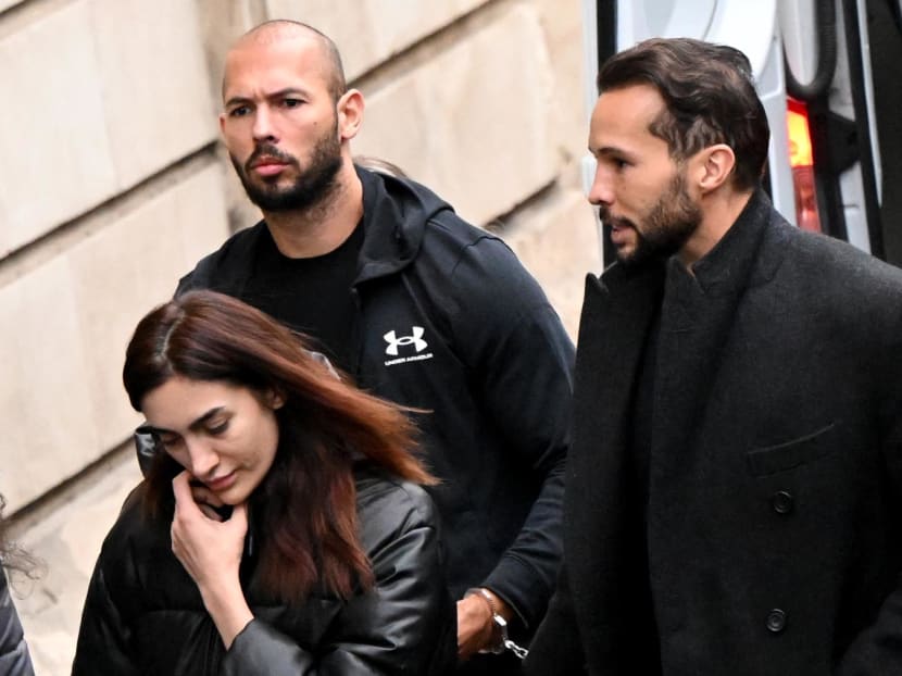 British-US former professional kickboxer and controversial influencer Andrew Tate (center), his brother Tristan Tate (right) arrive handcuffed and escorted by police at a courthouse in Bucharest on Jan 10, 2023 for a court hearing on their appeal against pre-trial detention for alleged human trafficking, rape and forming a criminal group.
