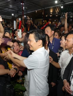 A jubilant crowd of residents greeting and shaking hands with Prime Minister Lawrence Wong at a viewing party in Yew Tee on May 15, 2024. 