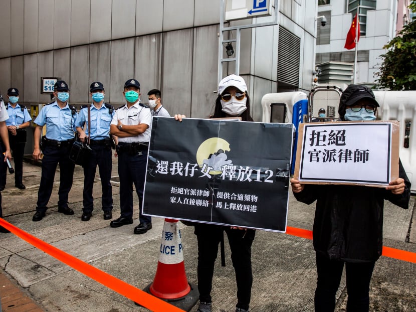 Family members of some of the 12 Hong Kong residents who were intercepted and detained in mainland China after they were caught trying to flee serious protest-linked prosecutions by boat in Hong Kong in August, hold placards as they gather outside China's Liaison Office to petition for the return of the 12 to Hong Kong.