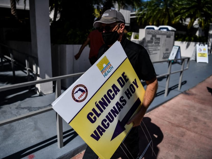 A city employee sets up a sign directing to a pop-up vaccination site in Miami Beach, Florida on April 8, 2021.