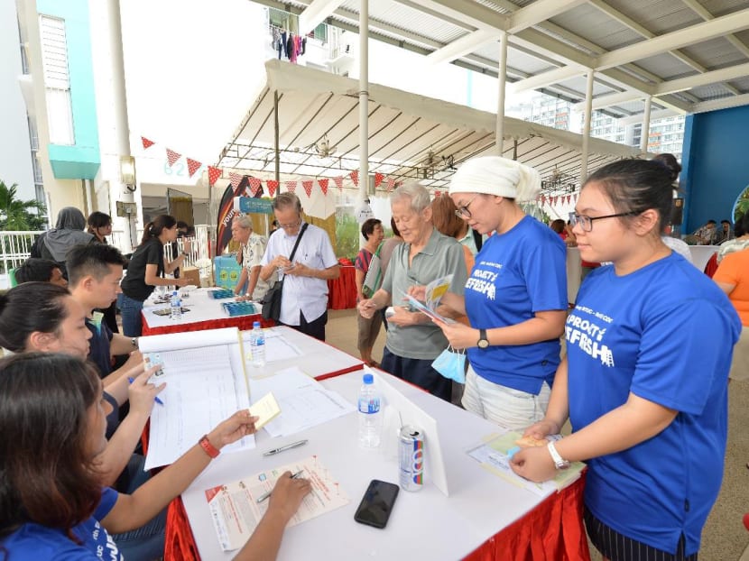 Residents collecting their S$25 SSUL vouchers to exchange for LED lights under the “Switch and Save - Use LED” programme.