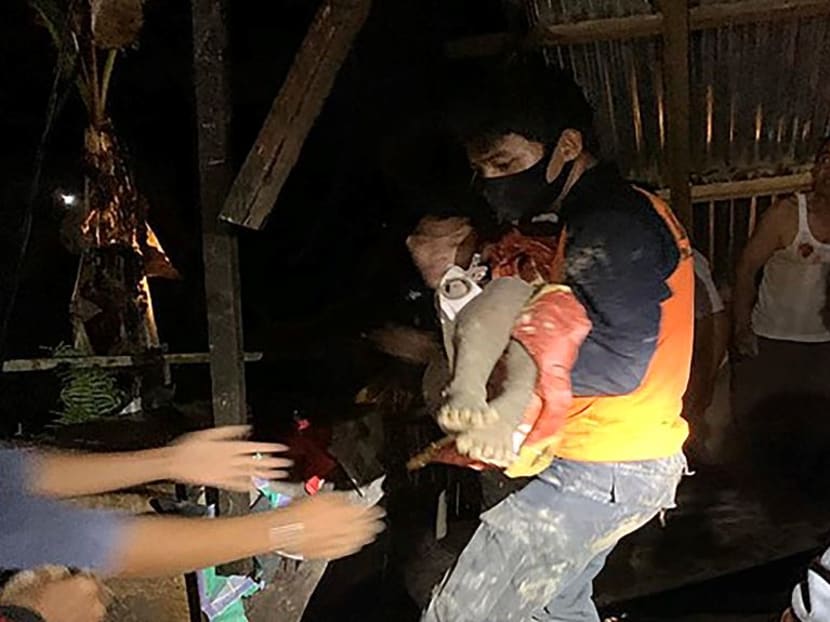 This handout photo taken on Sept 28, 2020 and released by North Kalimantan agency for Disaster management shows a rescuer saving a child after landslides struck in four separate locations in Tarakan, the largest city of the North Kalimantan province, after hours of heavy rains and strong winds that has killed 11 people.