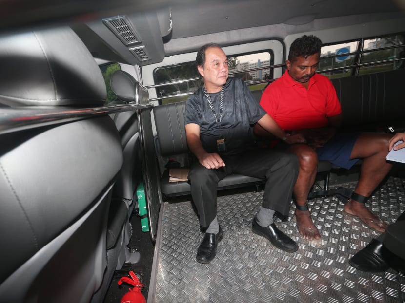 Krishnan Raju (right) being escorted by the police back to the scene of the crime in November 2017. Krishnan Raju (right) being escorted by the police back to the scene of the crime in November 2017.