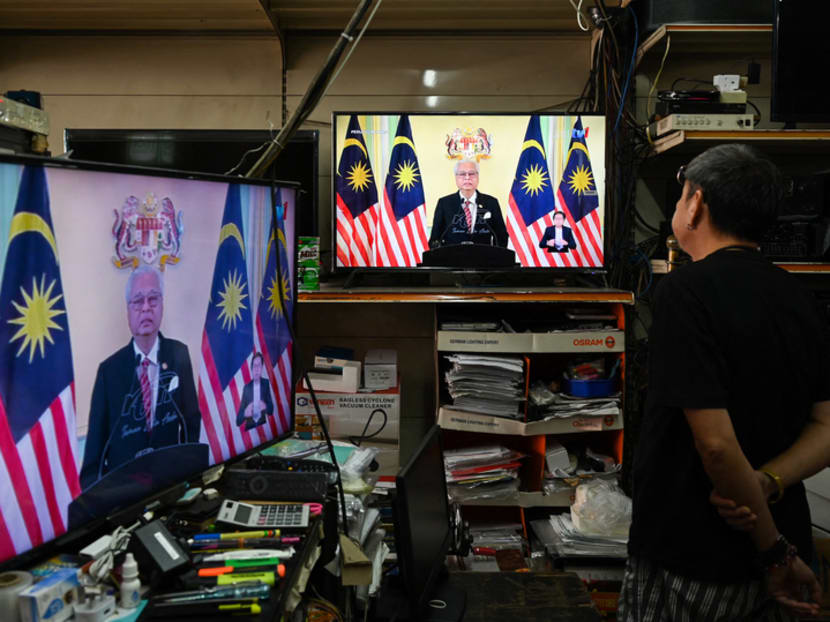 A man watches television on display at a shop in Malaysia's Pahang state as the country's Prime Minister Ismail Sabri Yaakob announces the dissolution of parliament during a live telecast on Oct 10, 2022.