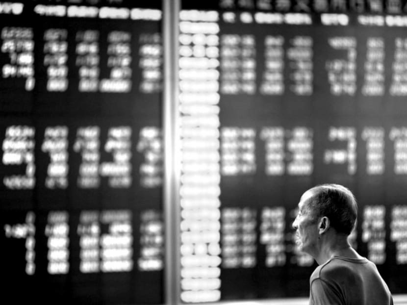 An investor looking at an electronic board displaying stock information in Beijing on Tuesday. After reaching a peak on June 12, the Shanghai index fell 30 per cent in only three weeks. By July 3, the Shanghai and Shenzhen exchanges shed almost S$4.1 trillion in market capitalisation. Photo: Reuters