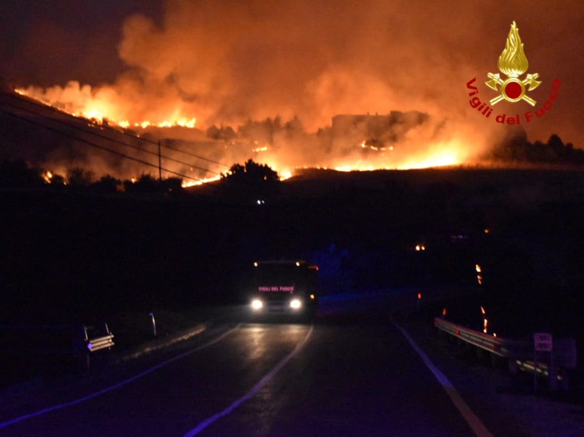 This handout picture taken and released on Aug 10, 2021 by the Italian Firefighters "Vigili del Fuoco" shows a firefighter engine driving as a fire rages around Palermo, Sicily, that have forced of people from their homes. This handout picture taken and released on Aug 10, 2021 by the Italian Firefighters "Vigili del Fuoco" shows a firefighter engine driving as a fire rages around Palermo, Sicily, that have forced of people from their homes.