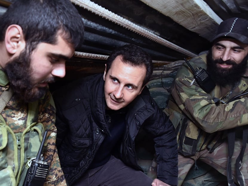In this Dec 31, 2014, file photo released by the Syrian official news agency SANA, Syrian President Bashar Assad, center, speaks with Syrian troops during his visit to the front line in the eastern Damascus district of Jobar, Syria. Photo: SANA via AP