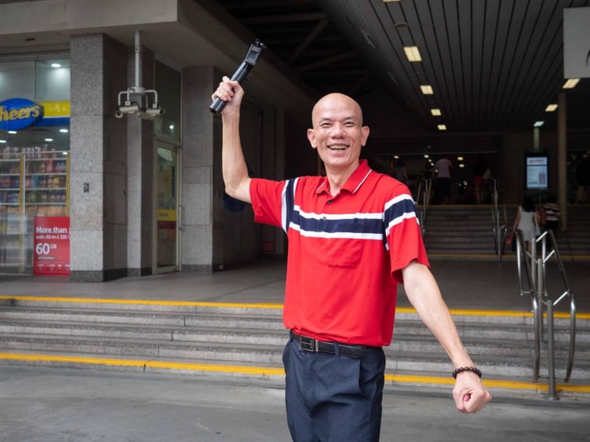 Mr&nbsp;Raymond&nbsp;Lim posing for a photo with the phone stand he uses to film TikToks outside Ang Mo Kio MRT station on June 17, 2022.