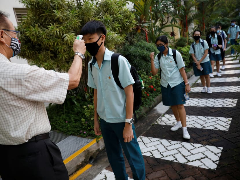 Students have their temperature checked at Yio Chu Kang Secondary School, as schools reopen amid the Covid-19 outbreak in Singapore, June 2, 2020.