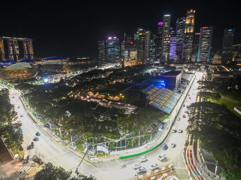 Cars drive on the illuminated race track for the upcoming Formula One Singapore Grand Prix night race at the Marina Bay Street Circuit in Singapore on Sept 26, 2022.