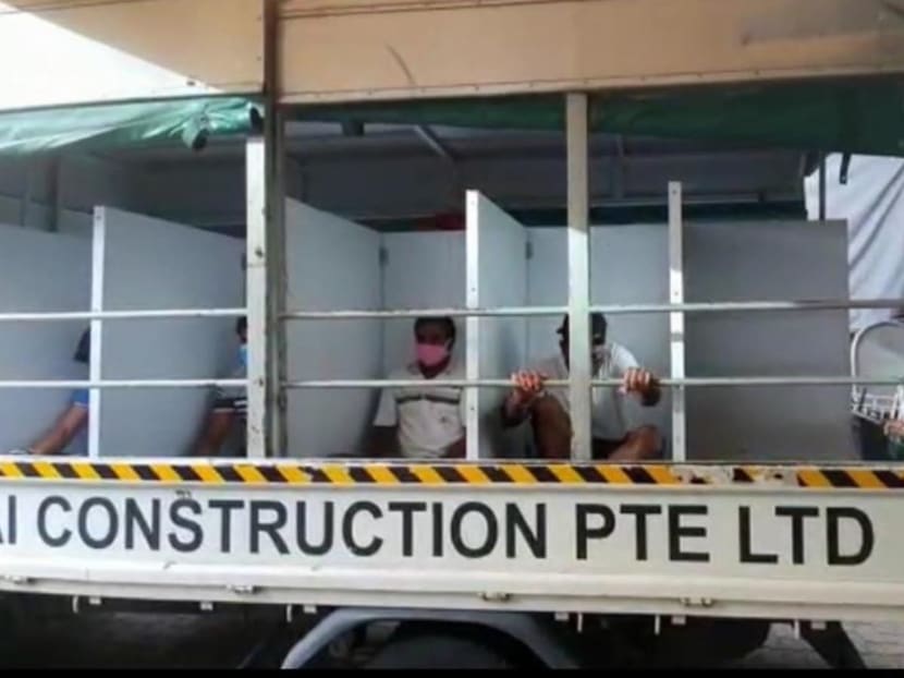 A still from a video circulating showing workers sitting between partitions at the back of a lorry.