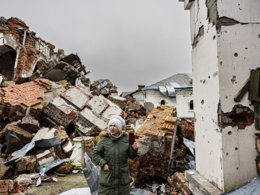 A local resident takes pictures of a destroyed monastery in Dolyna, eastern Ukraine on Dec 26, 2022.