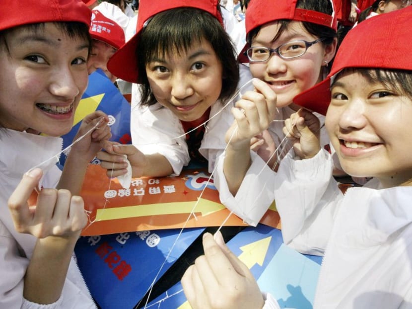 Students hold up pieces of dental floss during a Guinness World Record attempt to make the world's longest dental floss chain in Hong Kong, 22 February 2004. Photo: AP