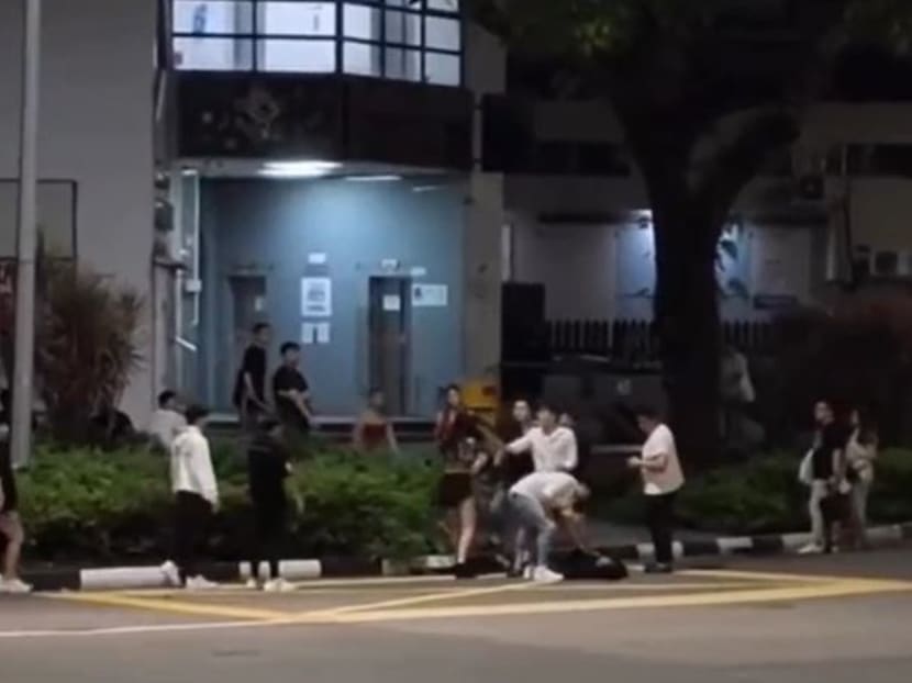 A screengrab of a video shared on online forum Reddit Singapore showing a group of young people beating up a youth.