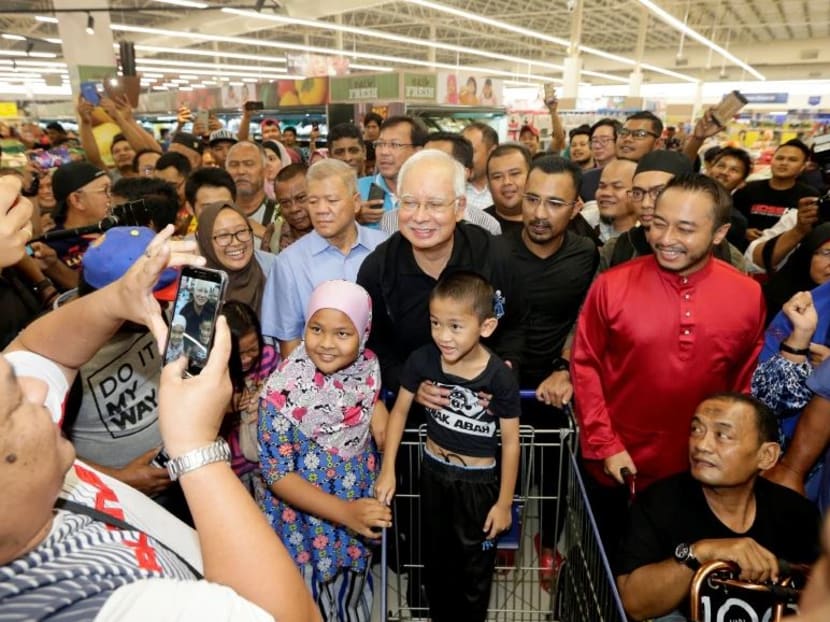 Najib Razak posing for photos with shoppers at the Tesco hypermarket in Semenyih on Feb 13.