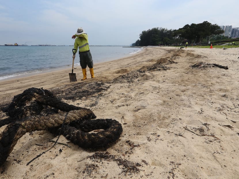 A worker wipes sweat off his brow as he cleans up part of a 400m stretch of beach along East Coast Park, which had been affected by an oil spill that occurred on July 20. Photo: Koh Mui Fong/TODAY