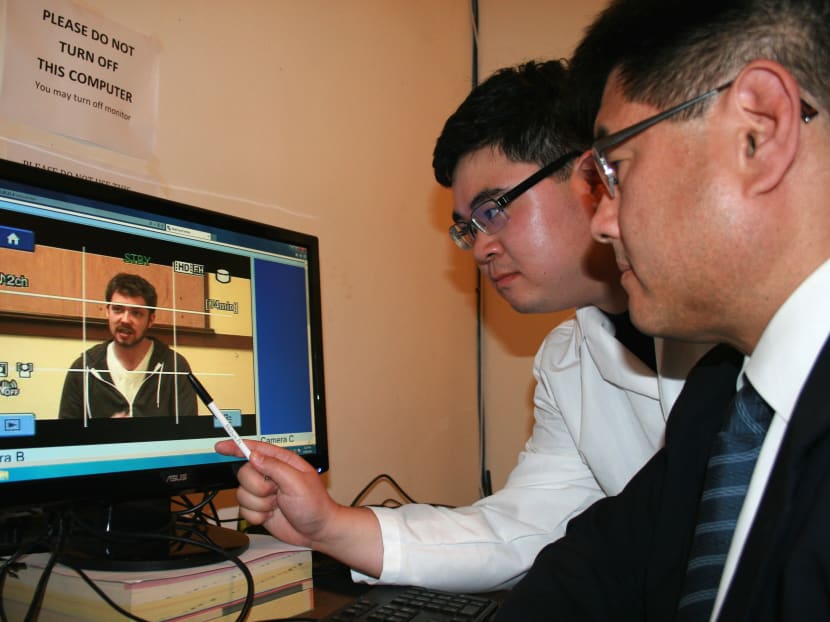 In this photo provided by Humintell, taken in 2013, San Francisco State psychologist and company CEO David Matsumoto, right, and colleague looking at the non-verbal behavior of another employee on video as part of their analysis for deception and emotional clues, in Berkeley, Calif. Photo: AP