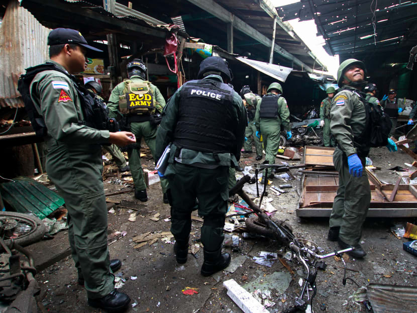Military personnel and police officers inspect the site of a bomb attack at a market in the southern Thai province of Yala in January 2018.