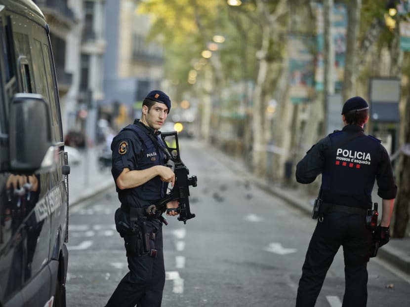 Armed police officers patrol a deserted street in Las Ramblas, in Barcelona, Friday, Aug 18, 2017. A white van jumped up onto a sidewalk and sped down a pedestrian zone Thursday in Barcelona's historic Las Ramblas district, swerving from side to side as it plowed into tourists and residents. Source: AP