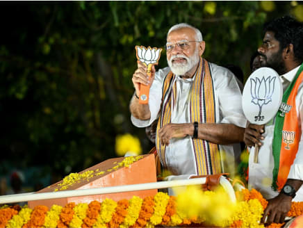Mr Narendra Modi, India's Prime Minister and leader of the ruling Bharatiya Janata Party (BJP), holds the party symbol during a road show at an election campaign held ahead of the country's upcoming general elections, in Chennai on April 9, 2024.