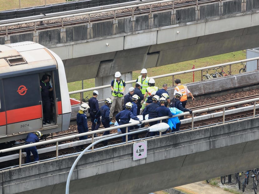 SCDF officers removing a body from the scene of the train accident at Pasir Ris MRT Station, which left two SMRT employees dead. Photo: Koh Mui Fong/TODAY