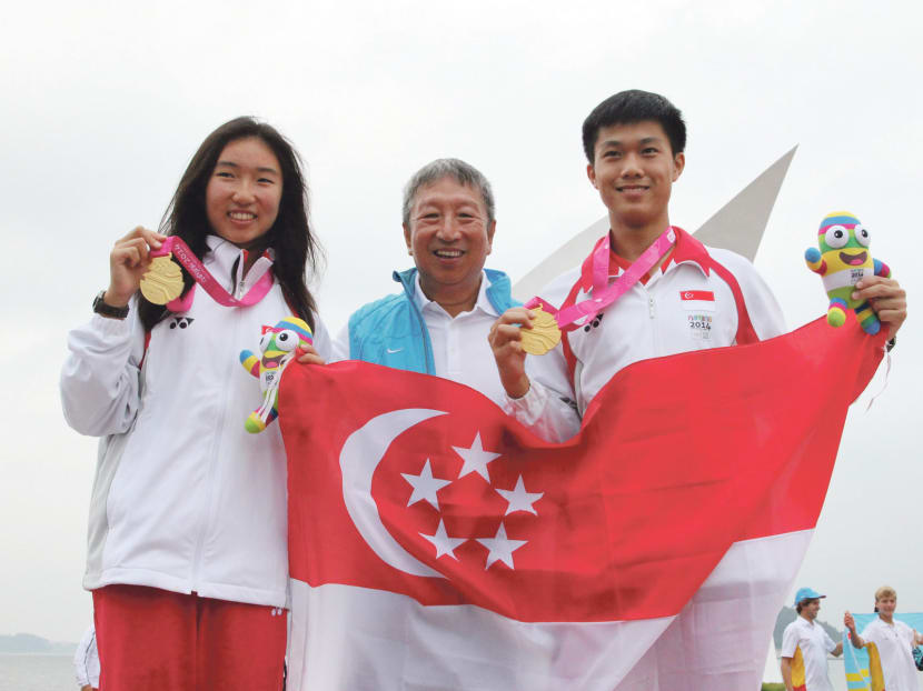 Sailors Samantha Yom and Bernie Chin celebrate their gold-medal wins with SNOC executive committee member Ng Ser Miang. Photo: SNOC